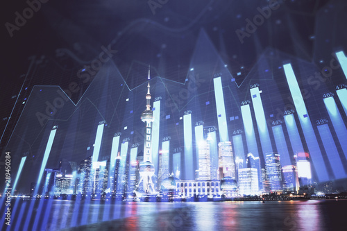 Financial graph on night city scape with tall buildings background multi exposure. Analysis concept.