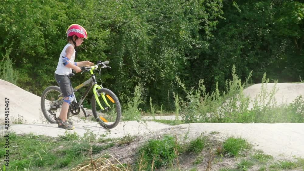 a boy in a helmet drives a mountain bike along the competition a boy in a helmet drives a mountain bike along the competition