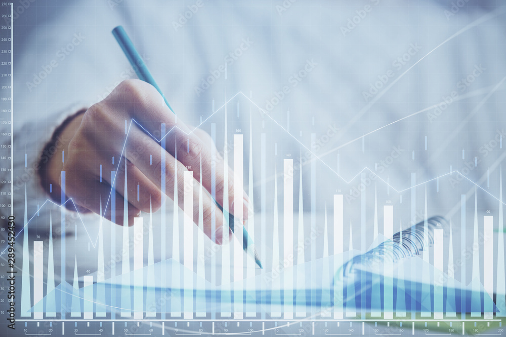 Financial forex graph displayed on hands taking notes background. Concept of research. Double exposure Financial forex graph displayed on hands taking notes background. Concept of research. Double exposure
