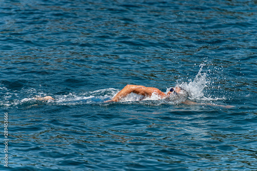 Male freestyle swimmer (Front crawl) in the blue waves of the Mediterranean sea