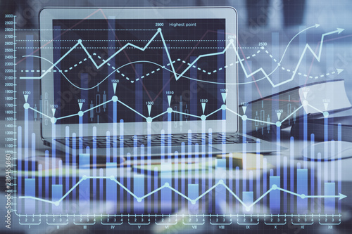 Financial graph colorful drawing and table with computer on background. Multi exposure. Concept of international markets. © peshkova