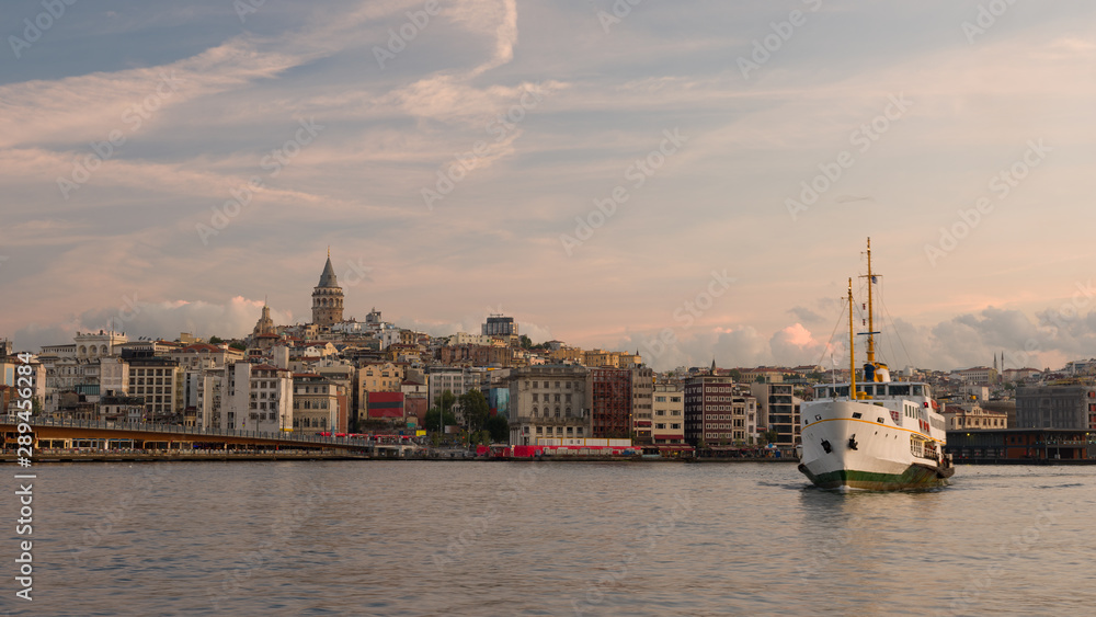 Panorama of Istanbul with Galata Tower. Entrance of Golden Horn at sunrise. Galata Bridge and cruise ships.