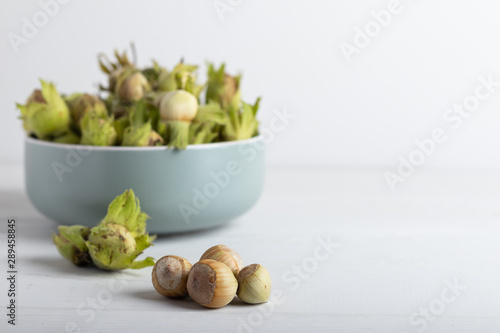fresh hazel nuts in a bowl on a white background