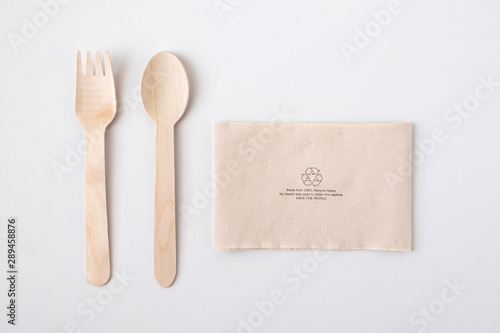 Recycle eco friendly disposable wood spoon fork and napkin paper in top view isolated on white table background. photo