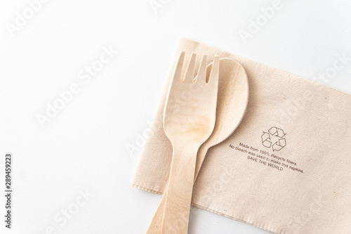 Recycle eco friendly disposable wood spoon fork and napkin paper in top view isolated on white table background. photo