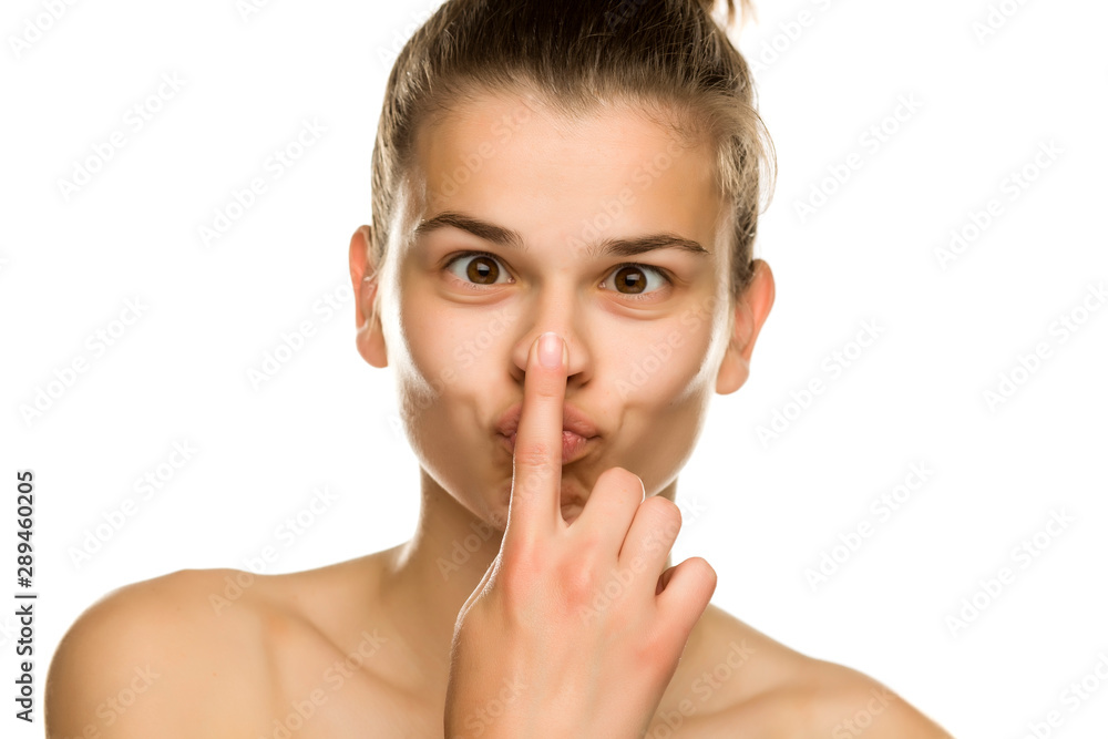 young funny woman touches her nose on white background young funny woman touches her nose on white background