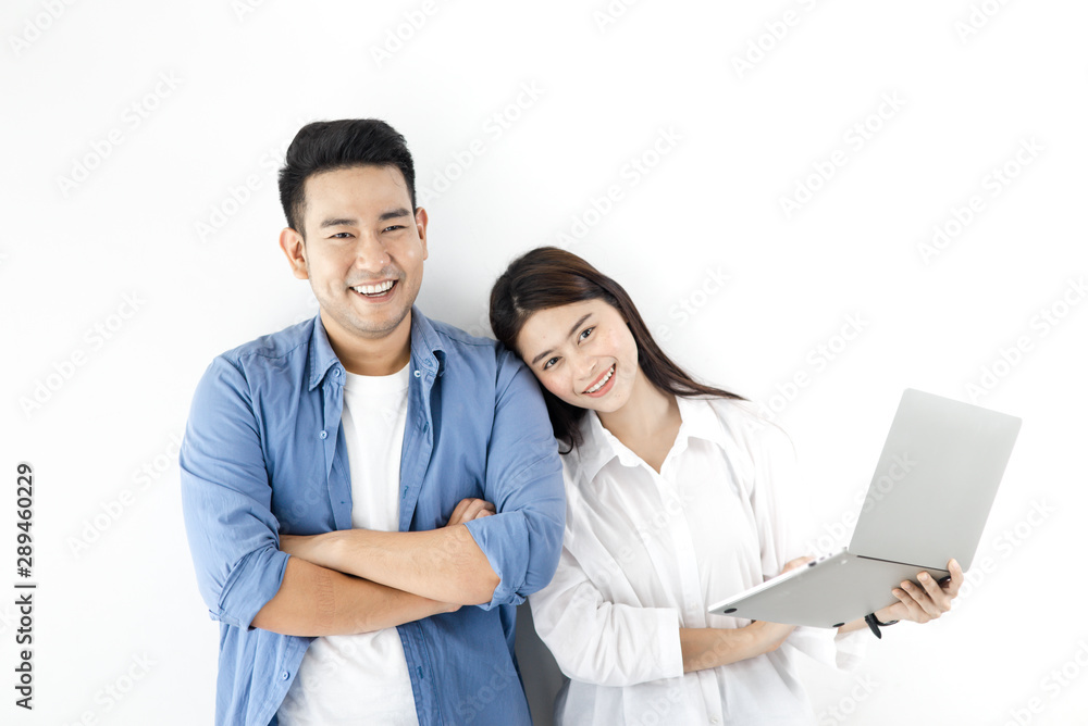 Happy Asian couple using laptop against white wall, lifestyle concept. Happy Asian couple using laptop against white wall, lifestyle concept.