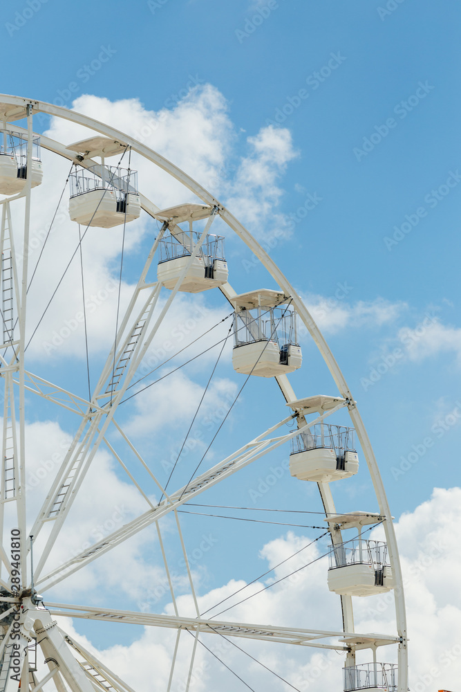 Ferris wheel on the blue cloudy sky. Background concept of happy holidays time. Ferris wheel on the blue cloudy sky. Background concept of happy holidays time.