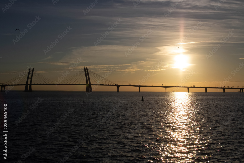Long cable-stayed bridge on the background of a beautiful sunset on the sea