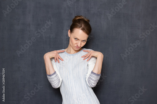 Studio shot of comic flirty woman imitating sexy photo pose