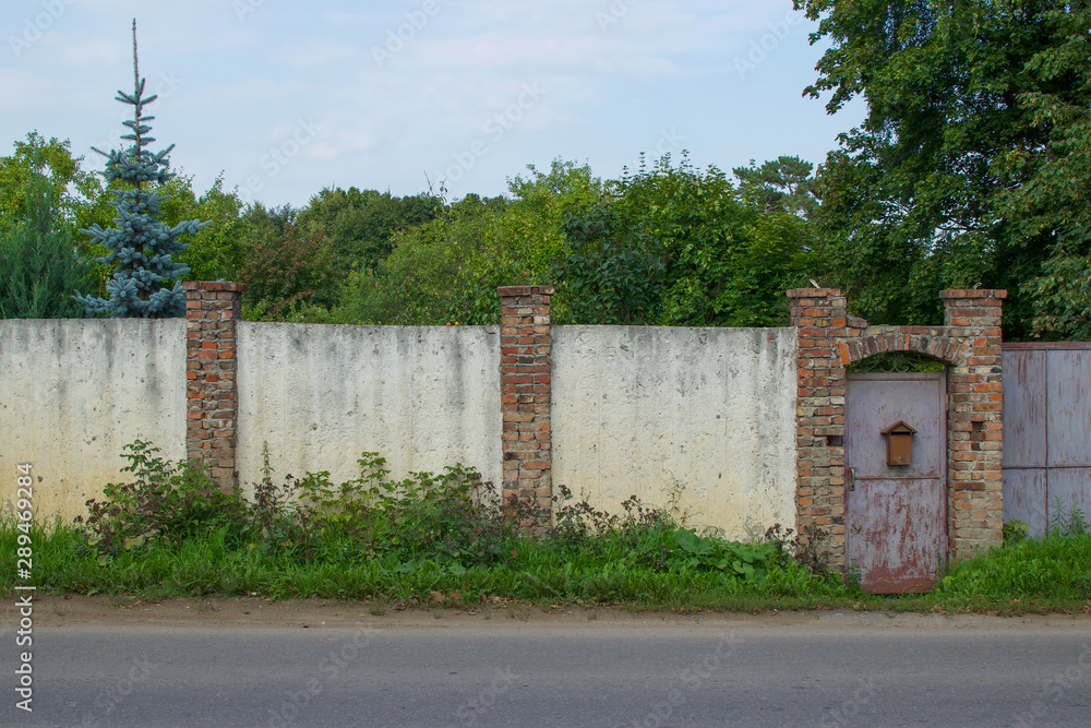 Old concrete fence with brick pillars