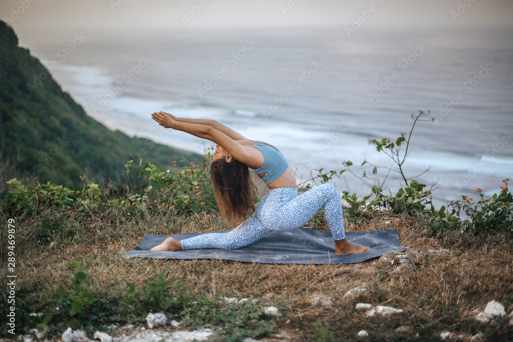 Girl practice yoga near ocean. - obrazy, fototapety, plakaty 