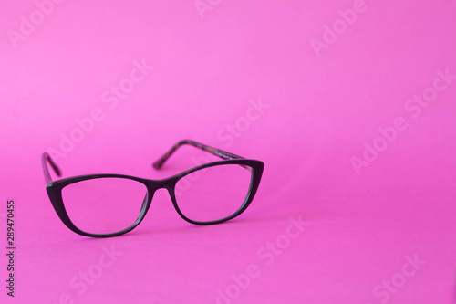 Fashionable stylish glasses on pink background. Optics. Vision.