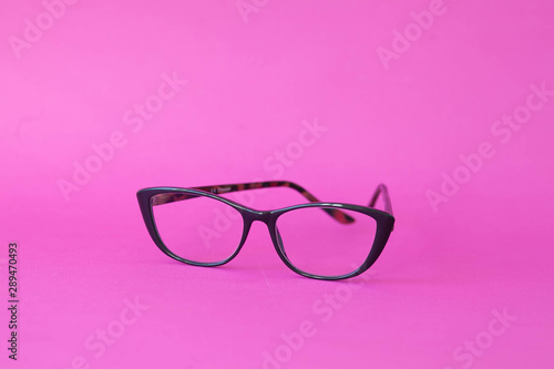 Fashionable stylish glasses on pink background. Optics. Vision.