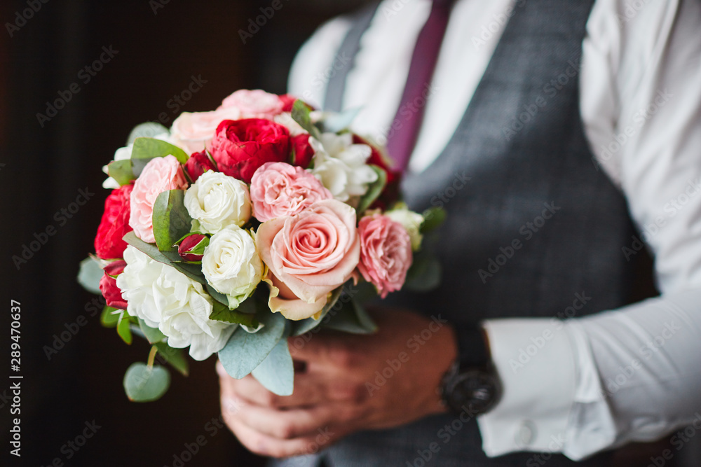 the groom holds a bouquet of flowers the groom holds a bouquet of flowers