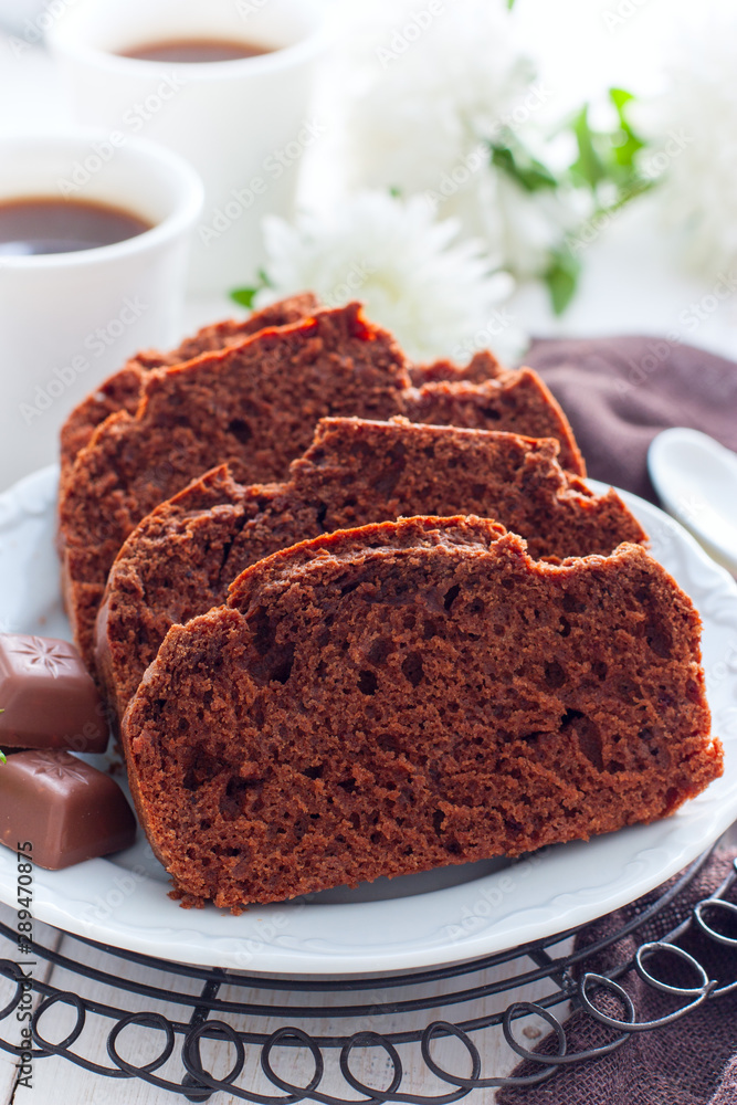 Sliced chocolate muffin on a white plate, selective focus Sliced chocolate muffin on a white plate, selective focus