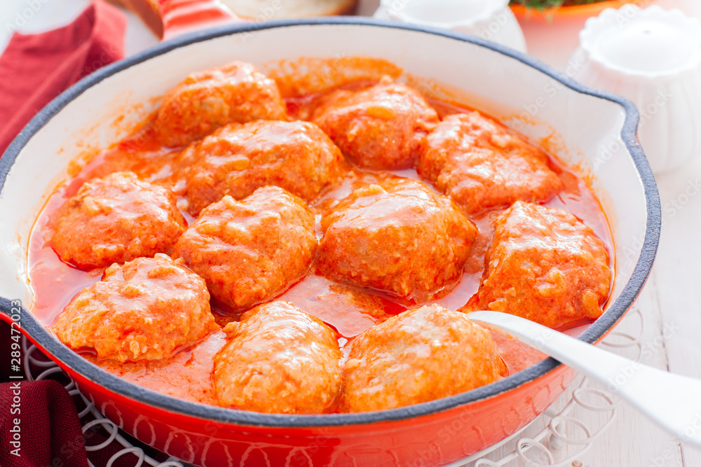 Chicken meatballs in a pan in tomato and sour cream sauce, horizontal