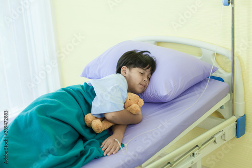 The patient boy are sleeping on the bed in hospital beacuse he are sick and want to rest