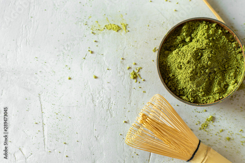 Matcha tea in a brown cup on a gray background