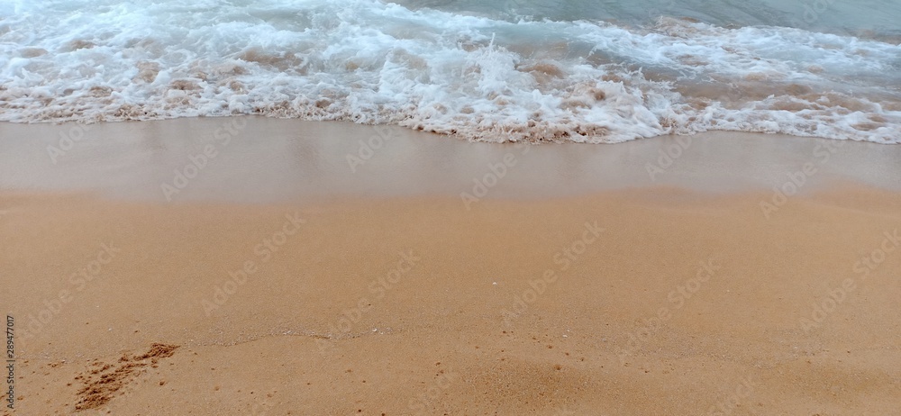 white waves on the golden sand in the beach sea background image