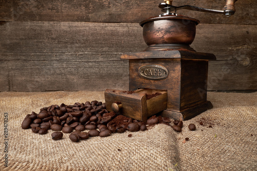 still life of coffee beans in jute bags with coffee grinder