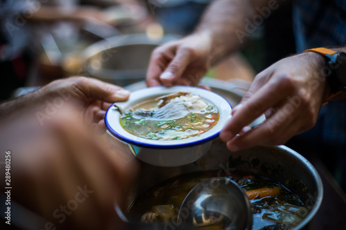 Person serving a portion of fish soup