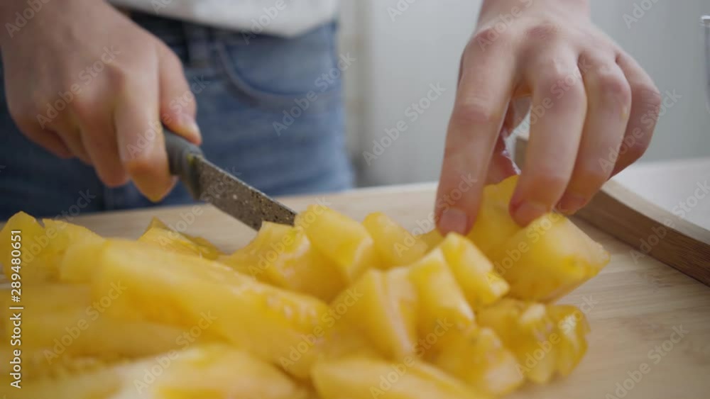 Closeup of female hands slicing big yellow tomato with the sharp knife at the table in the kitchen. Concept of healthy food. Profession of nutri therapist, nutraceutical, nutritionist. Closeup of female hands slicing big yellow tomato with the sharp knife at the table in the kitchen. Concept of healthy food. Profession of nutri therapist, nutraceutical, nutritionist.