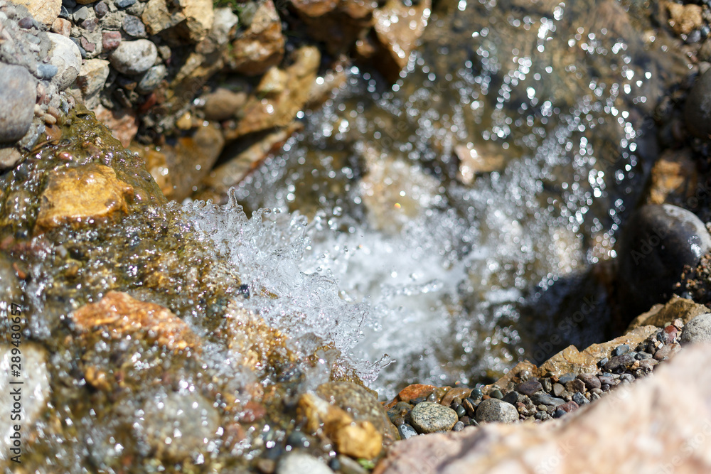 splashes and drops of a stream running over stones splashes and drops of a stream running over stones