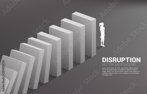 Silhouette of businesswoman standing at the end of domino collapse. Concept of business industry disrupt