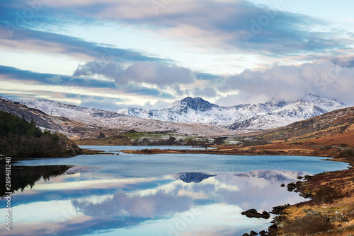Snow covered mountain range and blue lakes in snowdonia, wales, United Kingdom. © valdisskudre