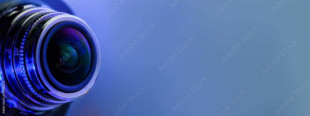 Banner. Camera lens with blue light. Side view of the lens of camera on  blue background. Camera Lens close Up. Optics Stock Photo | Adobe Stock