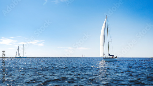 Yacht sailing in deep blue waters during sunny day.