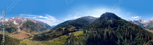 Aerial view Grossglockner Hochalpenstrasse, Alpine Road in Austria. Pine forest, sunny summer day, blue sky. Motorcyclists and travelers road. vacation and adventure, hiking and active lifestyle