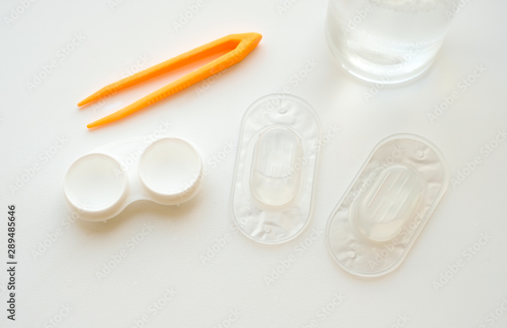Accessories for use of contact lenses: case, tweezers, blister pack and solution on white background. Safe vision correction. View from above. Accessories for use of contact lenses: case, tweezers, blister pack and solution on white background. Safe vision correction. View from above.