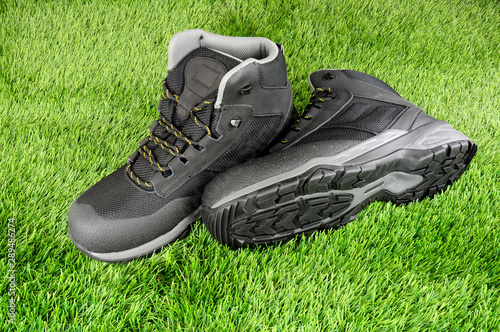 Pair of new work safety protection boots on an artificial grass background