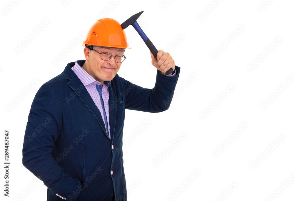 a man in a construction orange helmet tests the strength of the helmet with a hammer a man in a construction orange helmet tests the strength of the helmet with a hammer