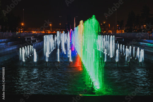 Colored fountain in the square at night