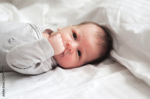 cute newborn baby in bed at home