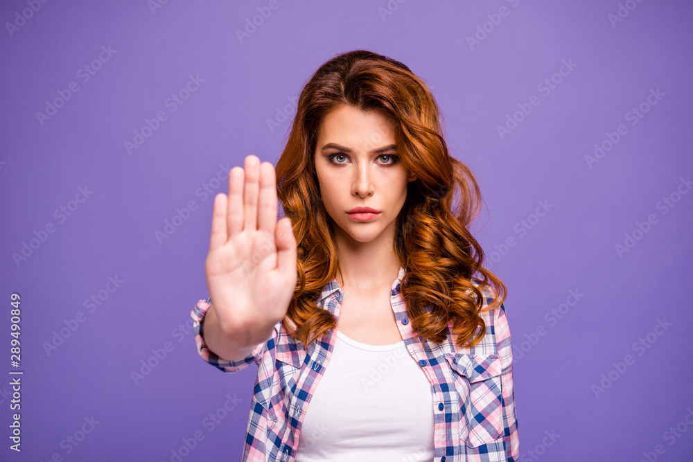 Photo of serious ginger lady raising palm to stop women violence wear casual checkered shirt isolated purple color background Photo of serious ginger lady raising palm to stop women violence wear casual checkered shirt isolated purple color background