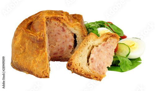 Crusty handmade savoury pork pie with salad and boiled egg isolated on a white background