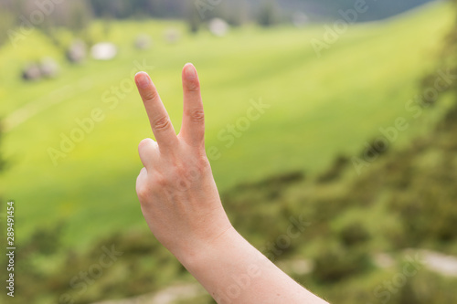 Hand Show Victory Sign. Hand with two fingers up in the peace symbol. Outdoors, lifestyle concept, Copyspace