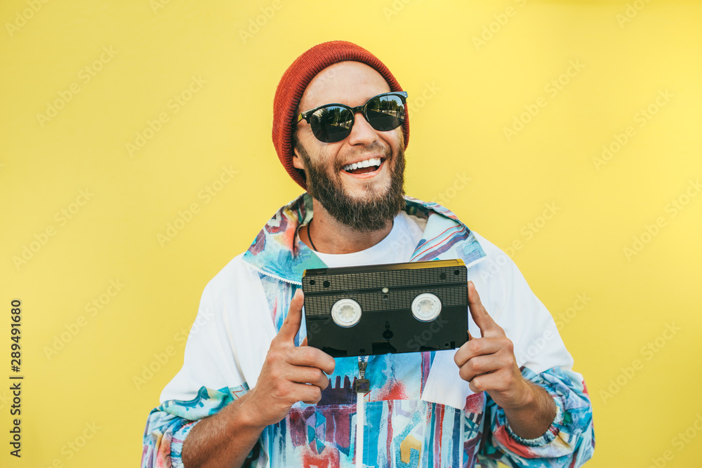 Stylish young hipster man with beard in red hat, sunglasses and a retro ...