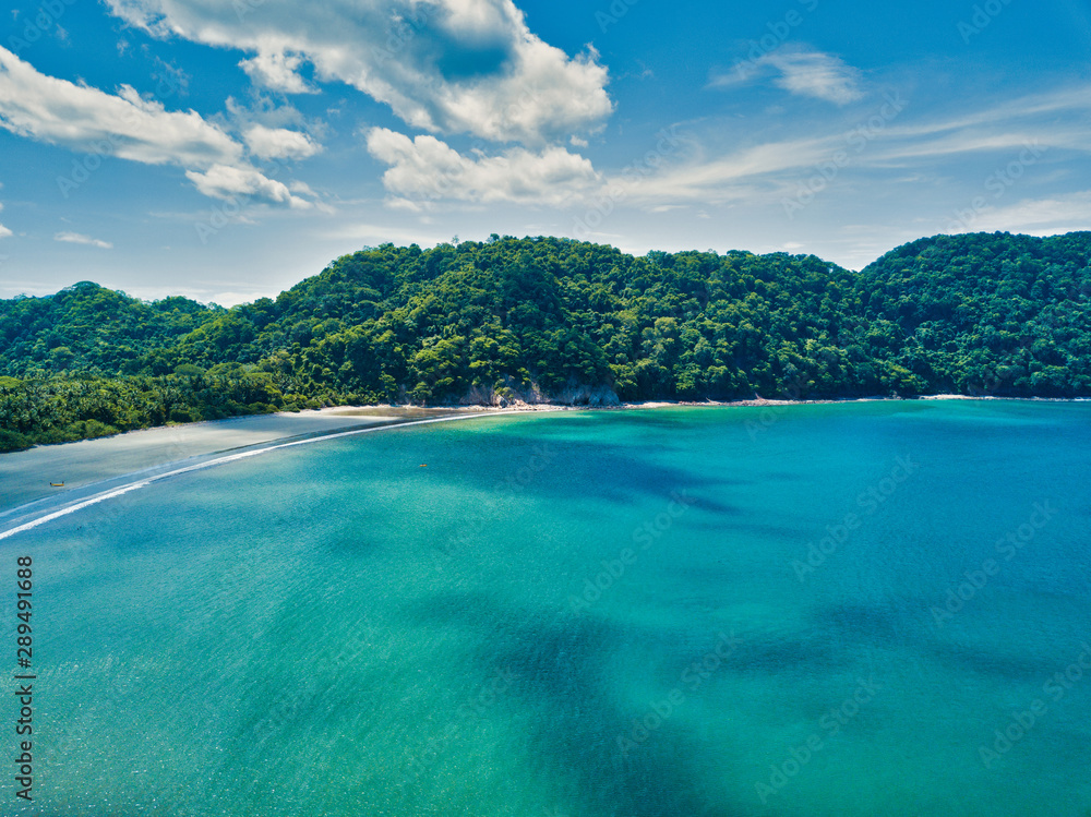 Aerial Drone image of The empty but beautiful beaches around the Gulf of Nicoya in Costa Rica with two small tourist boats near the waters edge
