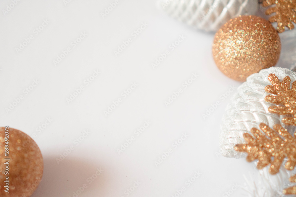 Christmas border with traditional decorations: balls, snowflakes, cones. Selective focus. Christmas composition in gold colors on white background with copy space. Concept for card invitation design Christmas border with traditional decorations: balls, snowflakes, cones. Selective focus. Christmas composition in gold colors on white background with copy space. Concept for card invitation design