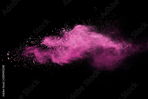 Pink powder explosion on black background. Paint Holi.