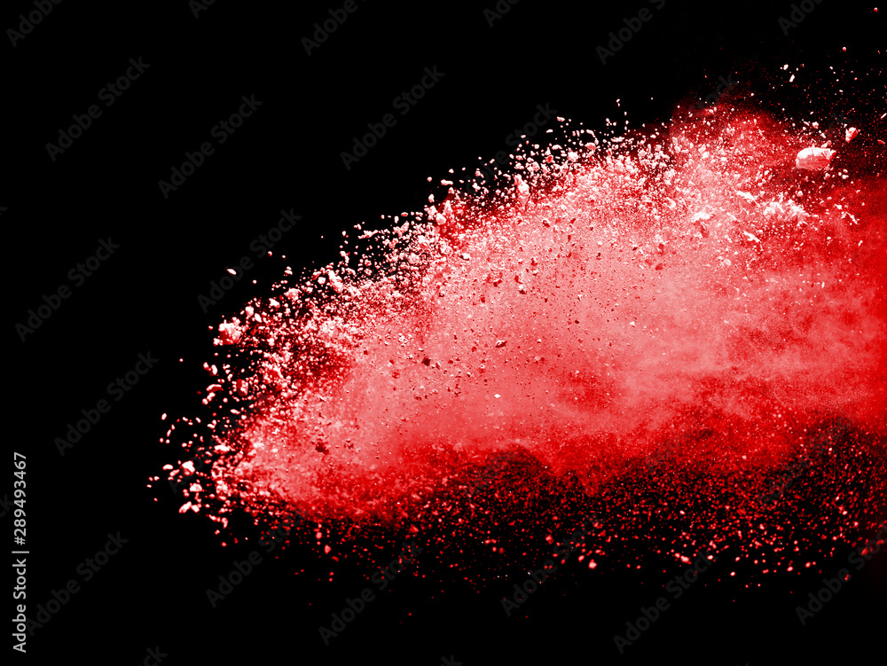 Red powder explosion on black background. Paint Holi.