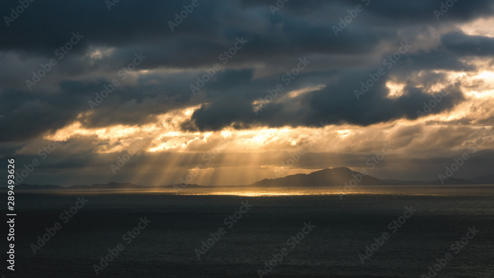 Beautiful seascape splitting rays cloudy clouds sun light sunset Scotland Neist Point