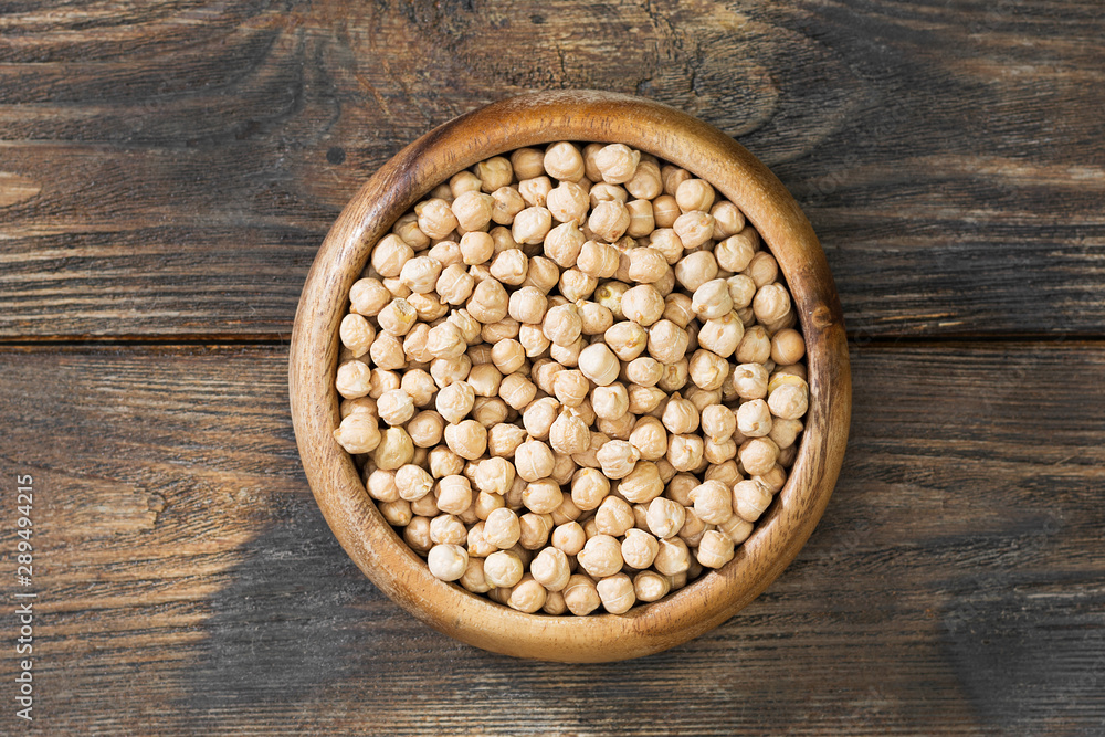 Chickpeas in a wooden bowl on a wooden table. Rustic style Chickpeas in a wooden bowl on a wooden table. Rustic style