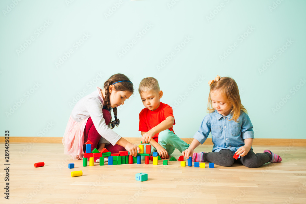 Fototapeta premium Children playing with colorful blocks at preschool