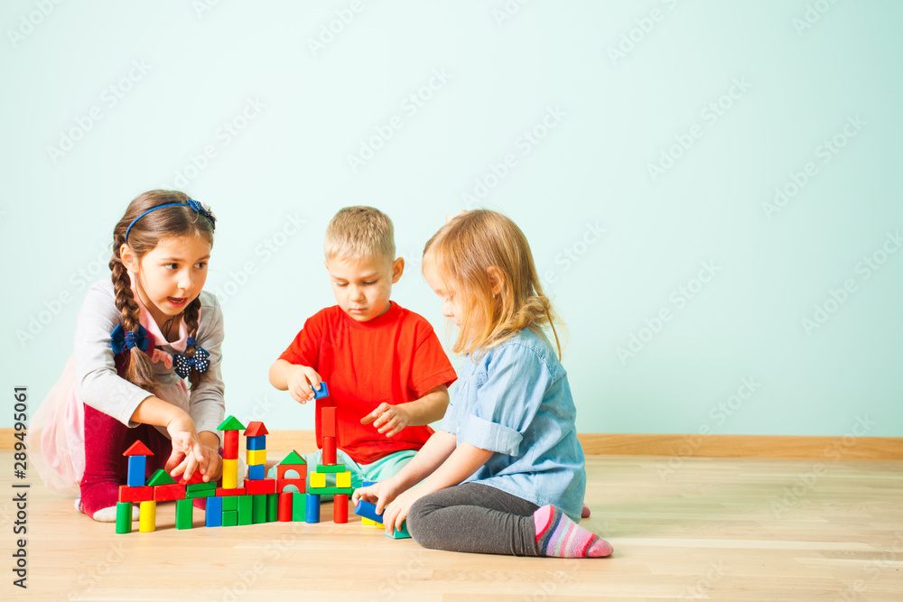 Young kids constructing towers from wooden blocks Young kids constructing towers from wooden blocks